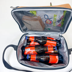 Interior of Lunch Box. Top zippered compartment for sandwiches and chips. Shows capacity of six bottles (horizontally) and up to 10-12 oz cans. A lunch packed with sandwich and chips in the top compartment. 6 long neck bottles in bottom.